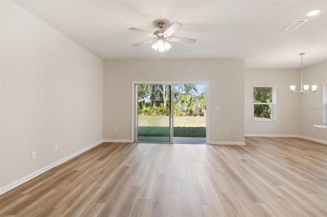 unfurnished room featuring ceiling fan with notable chandelier and light hardwood / wood-style flooring