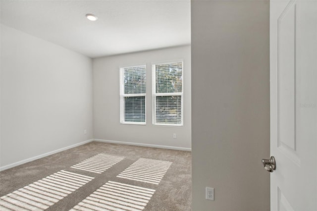 spare room featuring light colored carpet