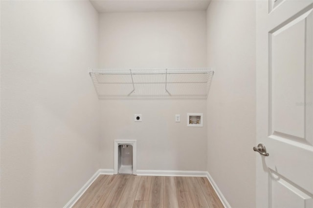 clothes washing area with electric dryer hookup, washer hookup, and light wood-type flooring