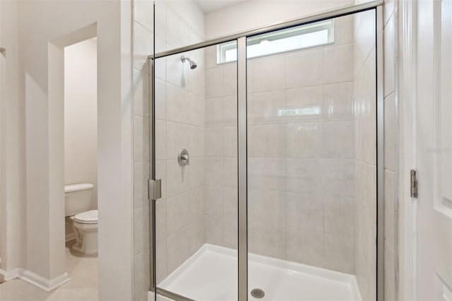 bathroom featuring an enclosed shower, tile patterned flooring, and toilet