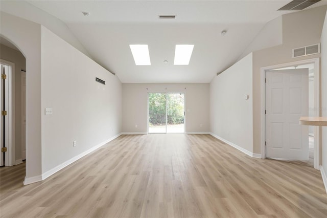 unfurnished room with lofted ceiling with skylight and light hardwood / wood-style flooring