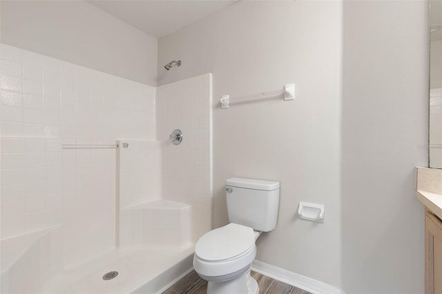 bathroom featuring toilet, a shower, vanity, and hardwood / wood-style flooring