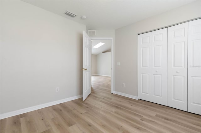 unfurnished bedroom with light hardwood / wood-style flooring and a closet