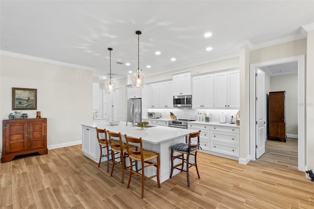 dining space featuring sink, ornamental molding, and light hardwood / wood-style flooring