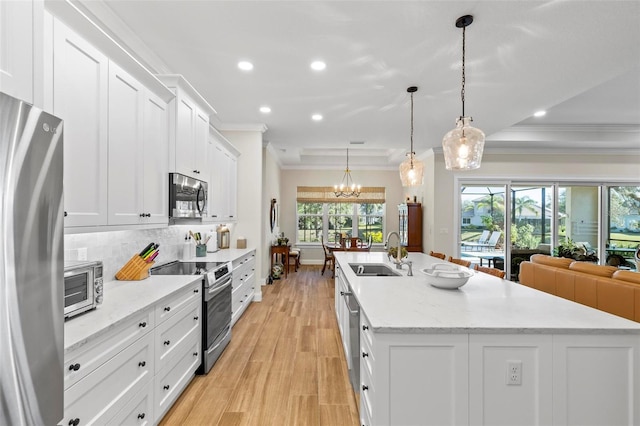 kitchen featuring a center island with sink, appliances with stainless steel finishes, white cabinetry, and sink