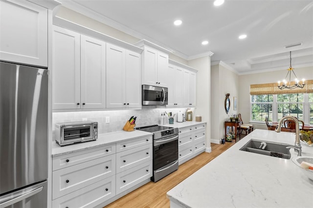 kitchen with light hardwood / wood-style flooring, a chandelier, stainless steel appliances, white cabinets, and sink