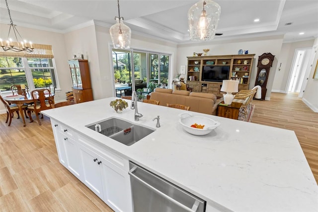 kitchen with light stone countertops, dishwasher, pendant lighting, and sink