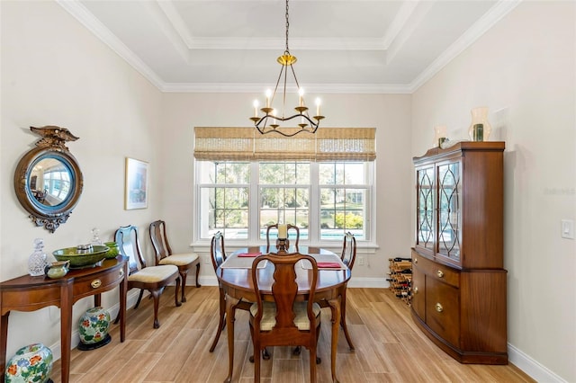 dining room featuring a raised ceiling, light wood-type flooring, and an inviting chandelier