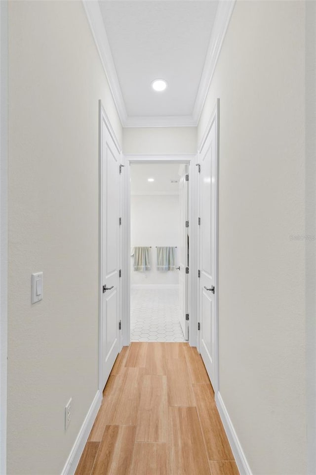 hall with crown molding and light hardwood / wood-style flooring