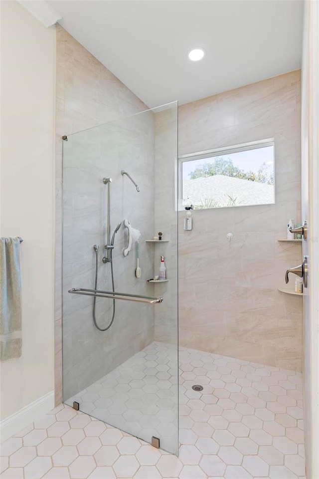 bathroom with a tile shower and tile patterned floors