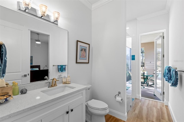 bathroom featuring toilet, crown molding, vanity, ceiling fan, and hardwood / wood-style flooring