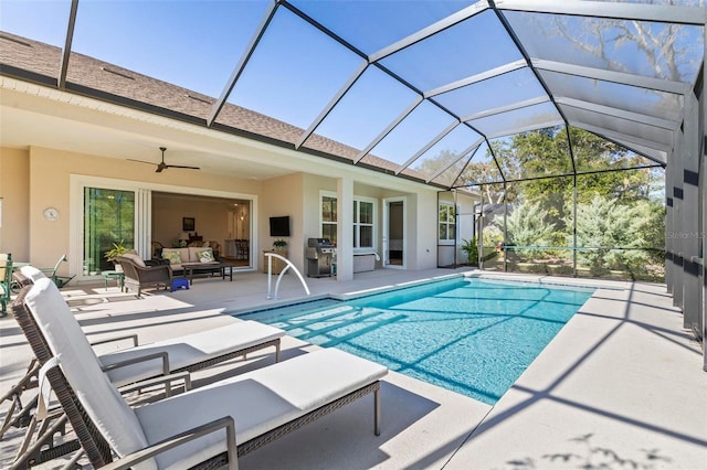 view of swimming pool with ceiling fan, a patio, glass enclosure, and outdoor lounge area