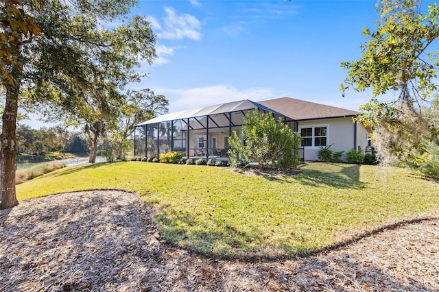 view of front of home with glass enclosure and a front lawn