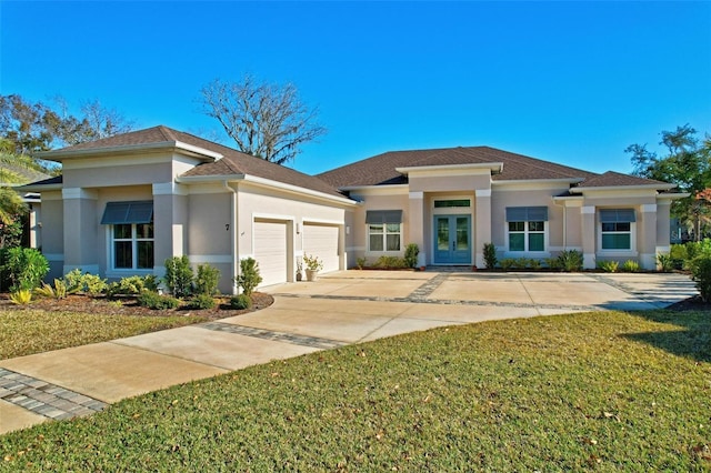 prairie-style home featuring a front yard, french doors, and a garage