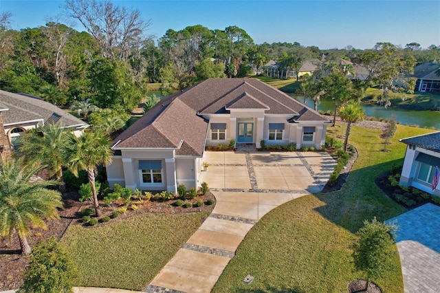 view of front facade with a front yard and a water view