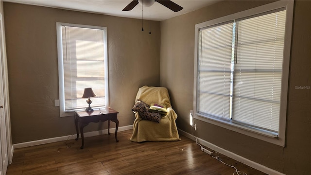 living area with ceiling fan and dark hardwood / wood-style flooring