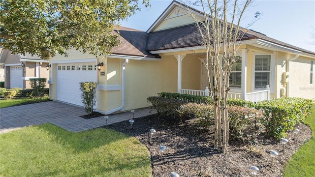 view of front of home with a porch, a front yard, and a garage