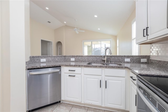 kitchen with appliances with stainless steel finishes, white cabinetry, lofted ceiling, and sink