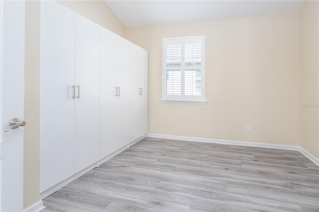 unfurnished bedroom with light hardwood / wood-style flooring and a closet