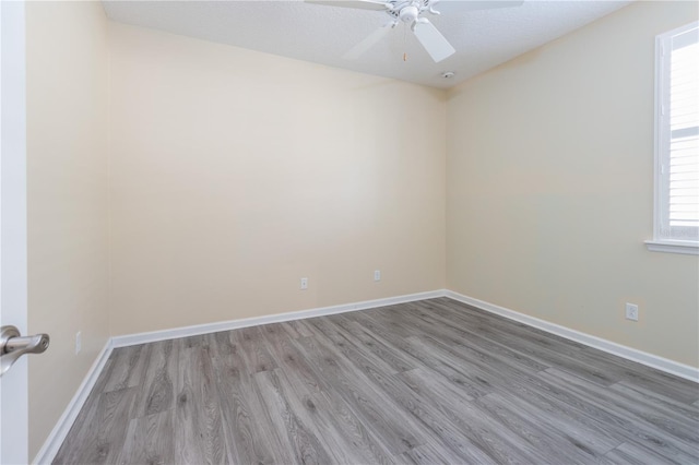 unfurnished room featuring light wood-type flooring, ceiling fan, and a textured ceiling