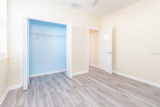 unfurnished bedroom with a closet, ceiling fan, and light wood-type flooring