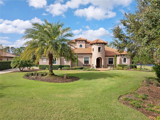 mediterranean / spanish home featuring a front lawn