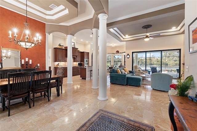 dining space featuring a towering ceiling, ceiling fan with notable chandelier, a tray ceiling, and ornamental molding