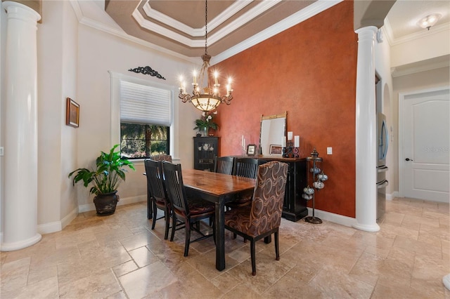 dining space with ornate columns, a raised ceiling, ornamental molding, and a notable chandelier