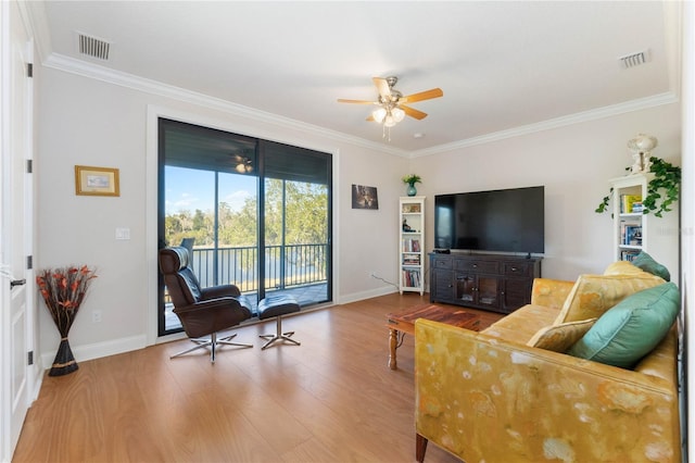 living room featuring ceiling fan, ornamental molding, and wood-type flooring