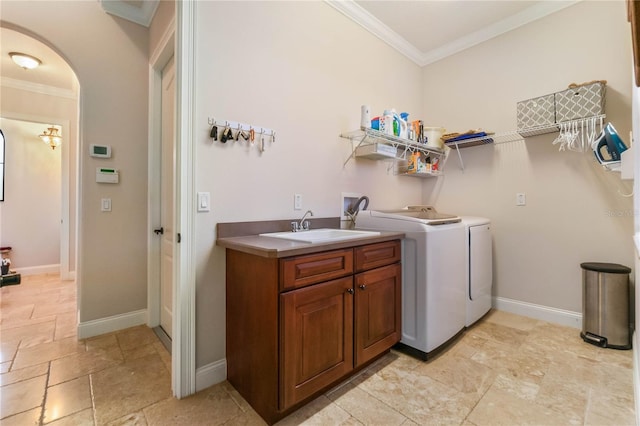 washroom featuring washer and clothes dryer, sink, crown molding, and cabinets