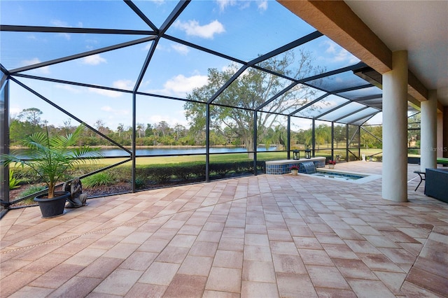 view of patio / terrace with a lanai, a water view, and an in ground hot tub