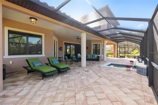 view of patio featuring ceiling fan, glass enclosure, and an outdoor hangout area