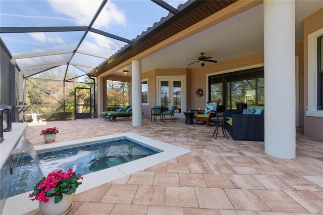 view of pool with glass enclosure, pool water feature, a jacuzzi, a patio, and an outdoor hangout area