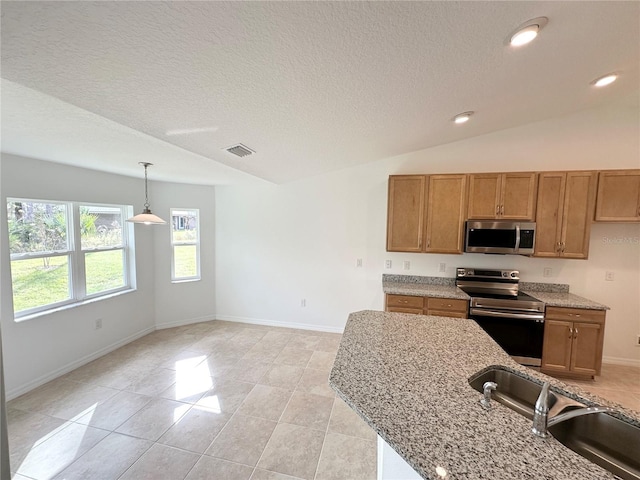 kitchen featuring sink, stainless steel appliances, decorative light fixtures, and light stone counters