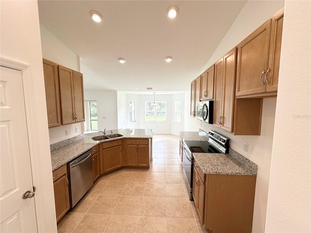 kitchen with appliances with stainless steel finishes, sink, a wealth of natural light, and kitchen peninsula