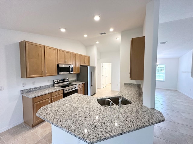 kitchen with stainless steel appliances, sink, vaulted ceiling, light tile patterned floors, and kitchen peninsula