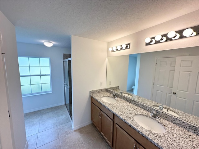 bathroom featuring an enclosed shower, a textured ceiling, tile patterned flooring, and vanity