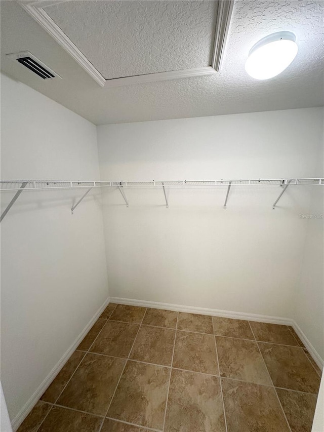 walk in closet with dark tile patterned floors