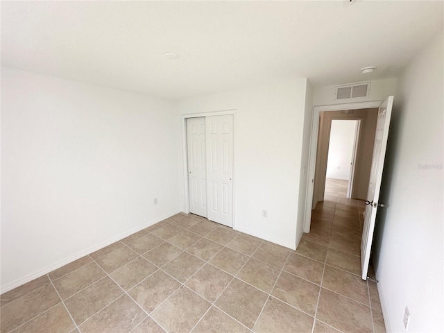 unfurnished bedroom with light tile patterned flooring and a closet