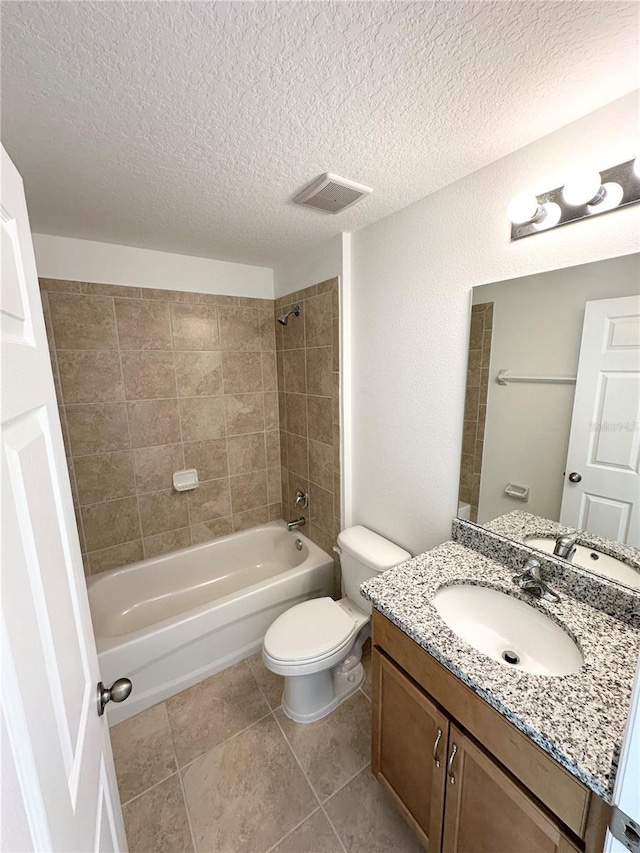 full bathroom featuring a textured ceiling, toilet, vanity, and tiled shower / bath