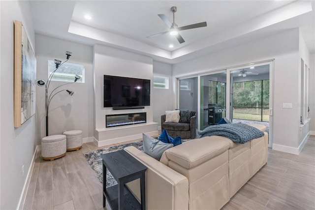 living room with a healthy amount of sunlight and a tray ceiling