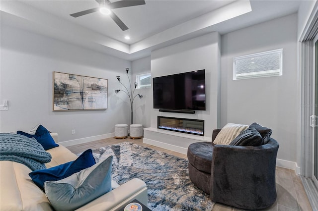 living room featuring light wood-type flooring, ceiling fan, and a wealth of natural light