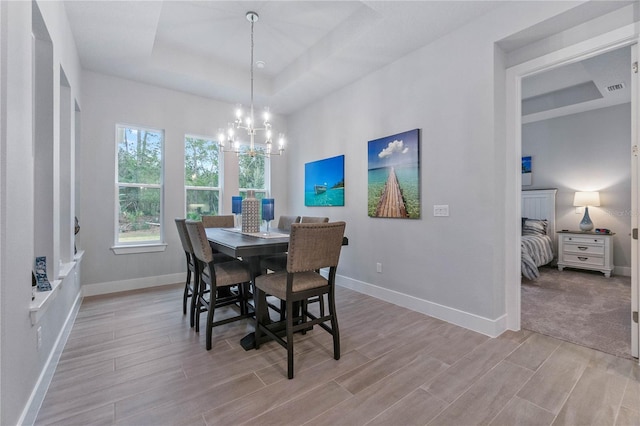 dining space featuring an inviting chandelier and a tray ceiling