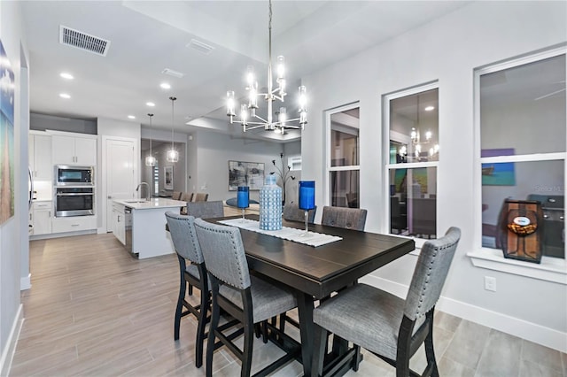 dining room featuring sink and a chandelier