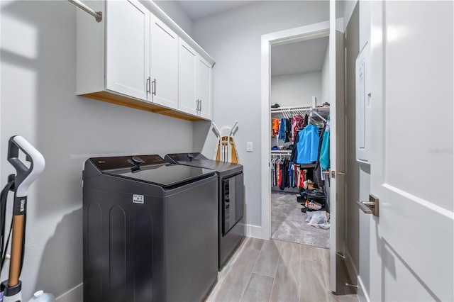 laundry area with washing machine and dryer and cabinets