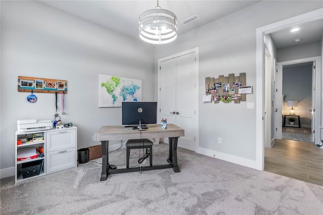 carpeted office space with a chandelier