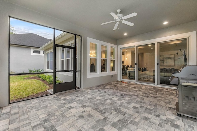 unfurnished sunroom featuring ceiling fan