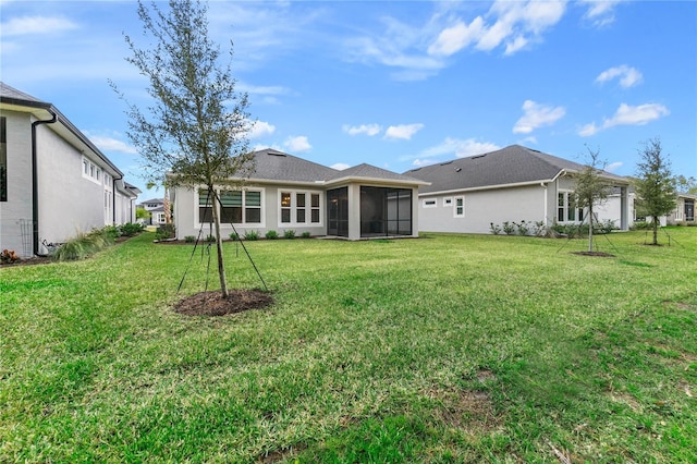 rear view of property with a yard and a sunroom