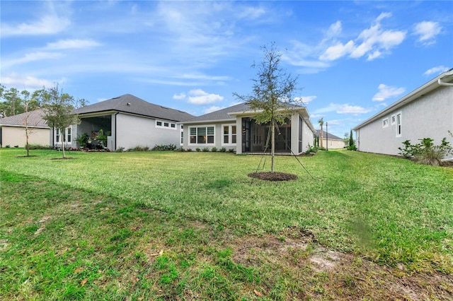 back of property featuring a yard and a sunroom