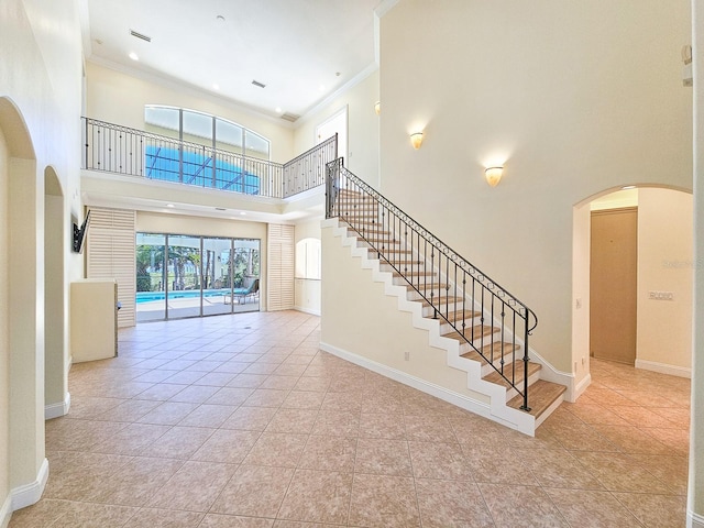 interior space with crown molding and a towering ceiling